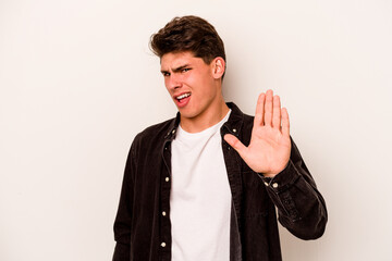 Young caucasian man isolated on white background rejecting someone showing a gesture of disgust.