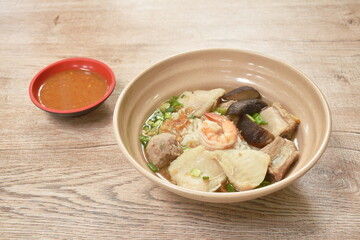 boiled rice with seafood and pork bone in clear soup on bowl dipping spicy sauce