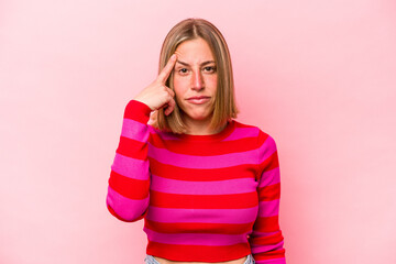 Young caucasian woman isolated on pink background pointing temple with finger, thinking, focused on a task.