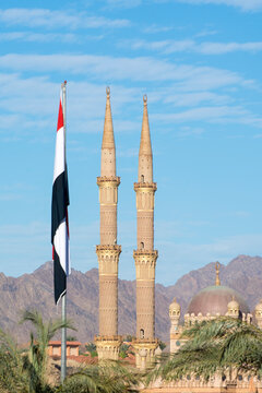 Sharm El Sheikh, Egypt - January 12, 2022: Al-Sahaba mosque in Sharm El Sheikh. Two minarets and egyptian flag on blue sky background.