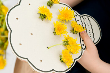 Kids sensory tool. DIY at home toy with natural dandelion. Fun outdoor flower decorating activity....