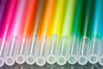 Refills of a colored pens close-up. Rainbow multicolor pattern. Blurred and defocused background.