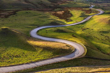 Winding curvy rural road leading through British countryside in The Peak District, UK. - 492580724