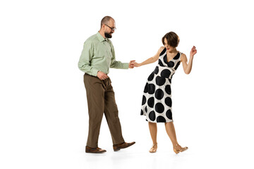 Dynamic portrait of couple of dancers in vintage retro style outfits dancing lindy hop dance isolated on white background. Concept of art, action, motion