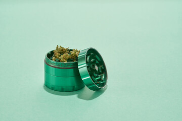 Opened jar with marijuana on green background
