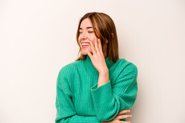 Young caucasian woman isolated on white background laughs happily and has fun keeping hands on...