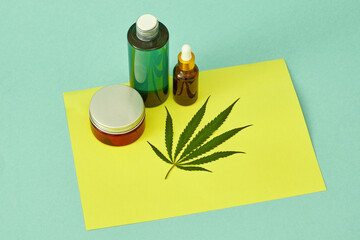 Top view of marijuana leaf and cannabinoid oils