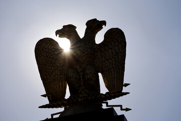 Silhouette of two-headed eagle against the sun. Russian imperial emblem, double-headed eagle with lightning in the paws