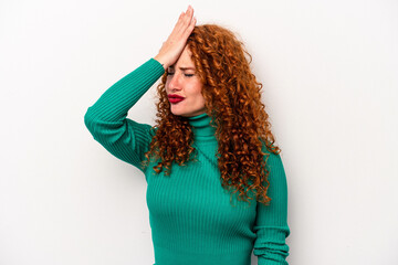Young ginger caucasian woman isolated on white background forgetting something, slapping forehead...