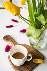 a fading bouquet of tulips and the remains of coffee on the table, the end