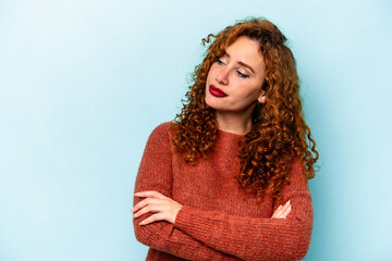 Young ginger caucasian woman isolated on blue background dreaming of achieving goals and purposes