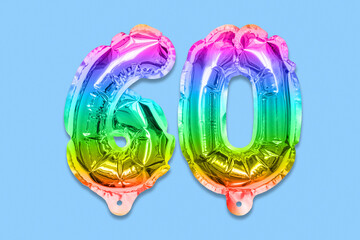 Rainbow foil balloon number, digit sixty on a blue background. Birthday greeting card with inscription 60. Anniversary concept. Top view. Numerical digit. Celebration event, template.
