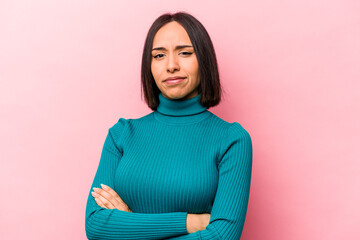 Young hispanic woman isolated on pink background unhappy looking in camera with sarcastic...
