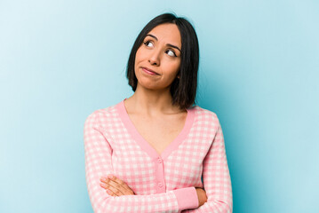 Young hispanic woman isolated on blue background dreaming of achieving goals and purposes