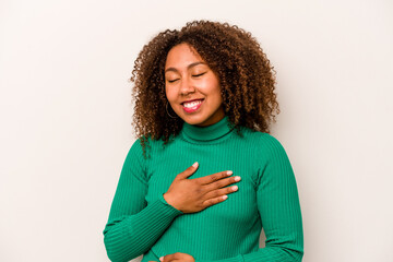 Young African American woman isolated on white background laughs happily and has fun keeping hands...