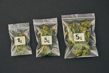 Set of packages with marijuana on black background