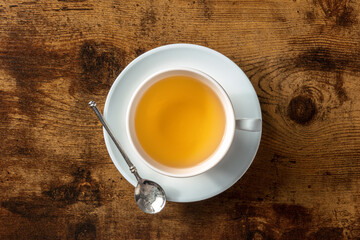 Obraz na płótnie Canvas A cup of tea, clean minimalist overhead shot on a dark rustic wooden background