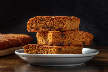 Blondie brownie dessert bars with chocolate chips, a close-up on a black background