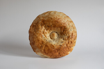 Uzbek bread from tandoor with raisin isolated on white background, patir, round bread.