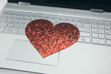 Heart on laptop keyboard. Online relationship, love and empathy concept.