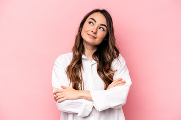 Young caucasian woman isolated on pink background dreaming of achieving goals and purposes