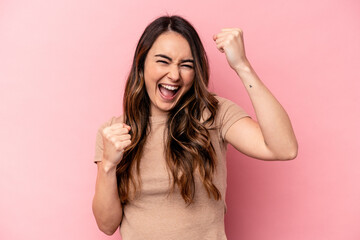 Fototapeta premium Young caucasian woman isolated on pink background cheering carefree and excited. Victory concept.