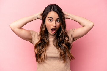 Young caucasian woman isolated on pink background screaming, very excited, passionate, satisfied...