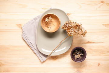 Hydrangea, dried flowers and plates on a wooden background, top view. Pastel, natural colors. Vintage style.