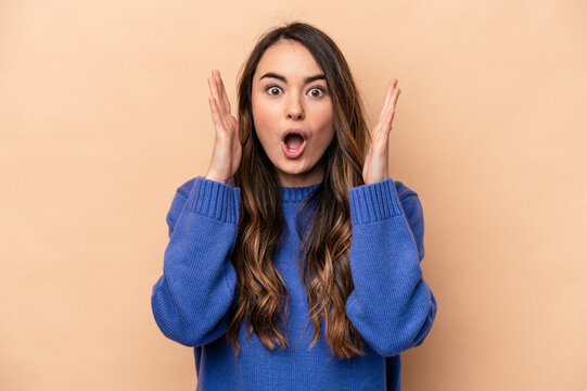Young caucasian woman isolated on beige background surprised and shocked.