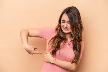 Naklejka premium Young caucasian woman isolated on beige background having a liver pain, stomach ache.