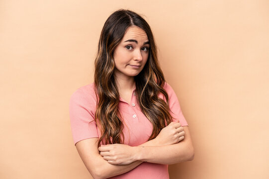 Young caucasian woman isolated on beige background unhappy looking in camera with sarcastic expression.