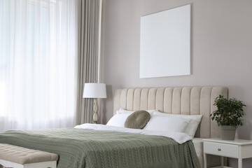 Blank canvas on wall in stylish bedroom interior. Space for design