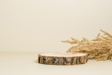 Wooden empty display with dry beige grass at the background, podium for product presentation