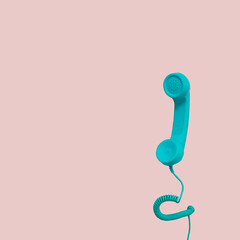Minimal pastel pink concept with bright blue phone handle and wire.