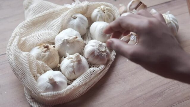  hand pick a garlic from a reusable bag 