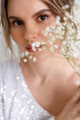 portrait of a woman with white gypsophila flowers. Facial skin care concept. Makeup and cosmetics, cosmetology medicine