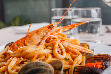 Piatto si Scialatielli ai frutti di mare con cozze, vongole, scampi, seppie e prezzemolo servito in un ristorante elegante