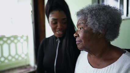 A teen granddaughter taking care of grandmother giving help and support