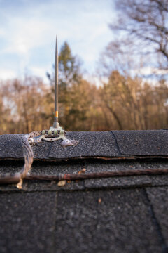 Close up of  lighting rod mounted on a residential roof to ground the structure from lightning damage and fire from static electricity discharge that can severely damage a home connect each rod