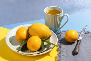 Fresh lemons on a plate on a bright background.
