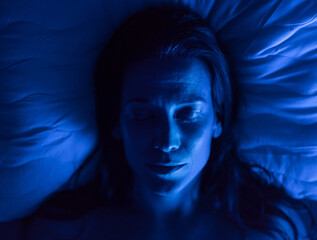 Close-up of woman sleeping in bed at night.