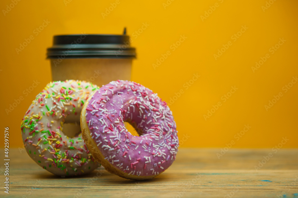 Wall mural Glazed donuts on wooden background