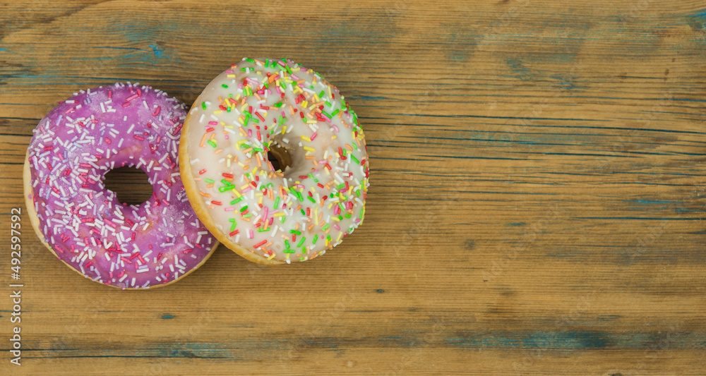 Wall mural glazed donuts on wooden background