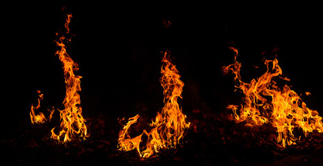 Panorama Fire flames on black background.global warming concept.Abstract background  sparks, dark glitter, light particles, light. Bonfire in motion blur.