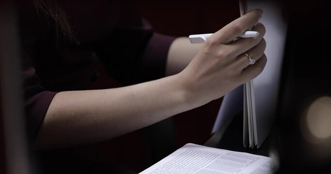 female hands puts the completed A4 sheet on the table, holding a white pen in her right hand, then takes a stack of papers and aligns it with a knock on the table. work with documents. close-up