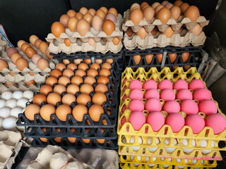 Organic eggs consist of duck eggs and chicken eggs placed in black plastic pit trays and paper trays, Century Egg with pink shell placed in yellow plastic pitted trays for sale to customers.
