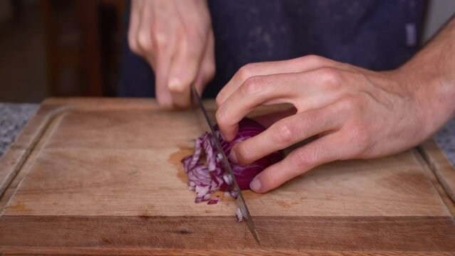 Chef showing how to cut onion into cubes