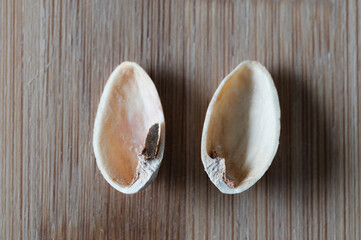 Top view of two empty pistachio shells on wood background