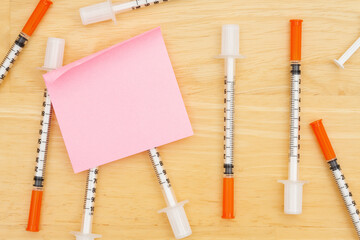 Disposable vaccine needle on desk with a sticky note