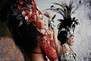 Feeling the beat. Shot of two beautiful samba dancers performing in a carnival.